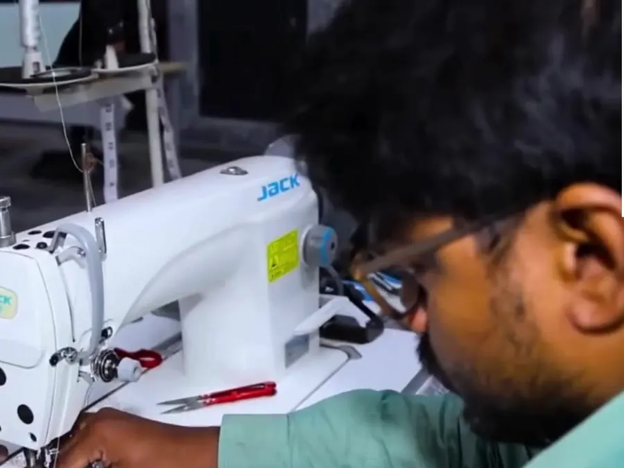 Team member stitching suit fabric on an industrial sewing machine